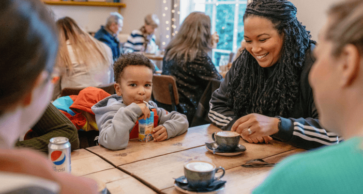 A mum and her little boy sat enjoying the Calderstones Cafe, smiling and drinking